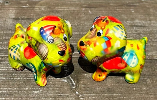 Twee keramieken hondjes van Pomme Pidou in groen 'Air Balloons Gardengreen'-design, als vrolijk peper- en zoutstel op een tafel.